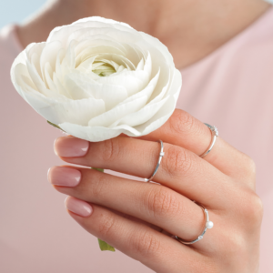 Niimi ring med hvid ferskvandsperle i sølv – ringe på hånden med en hvid blomst